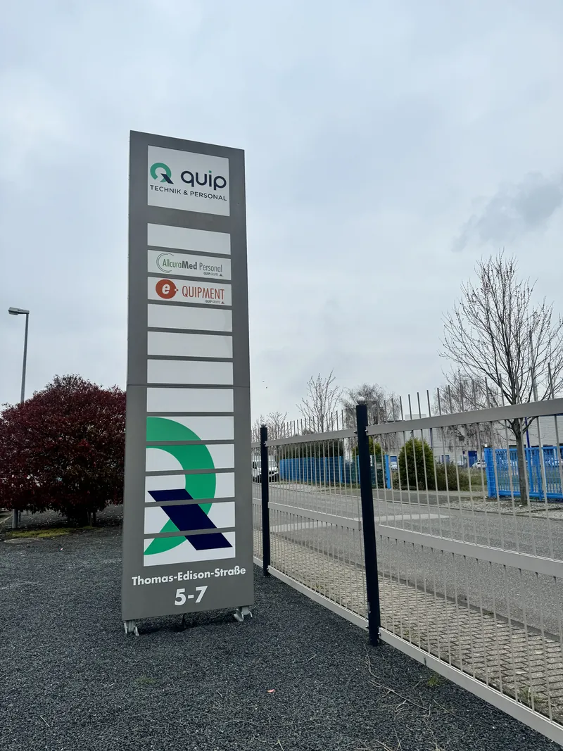 Standortschild der QUIP-Gruppe an der AllcuraMed-Geschäftsstelle Aachen